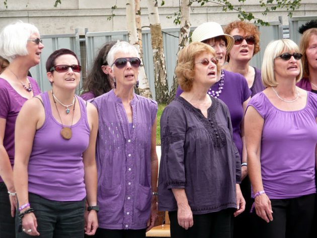 Bradford Voices singers in 2018, wearing purple