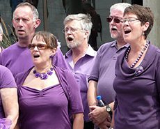 Men and women members of Bradford Voices,earing purple